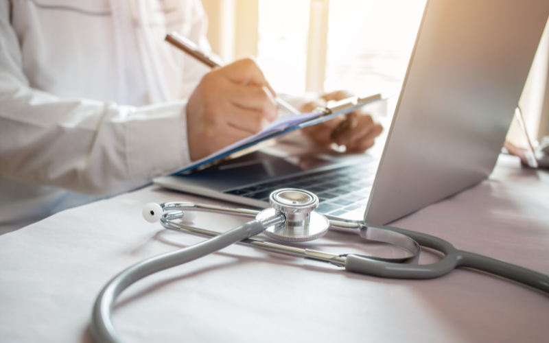 Doctor taking notes at a laptop