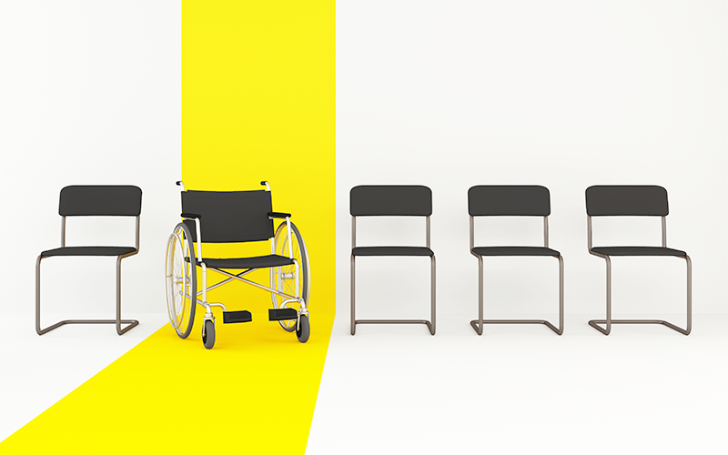 A line of chairs with a yellow strip highlighting a wheelchair as a symbol for visible disability